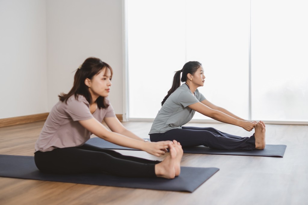 Seated forward fold on yoga mats
