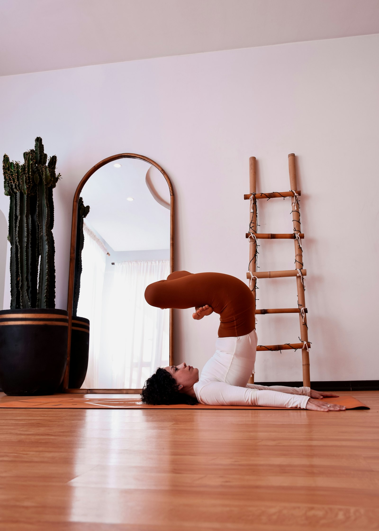 Woman holding a yoga pose on a mat in a calm studio